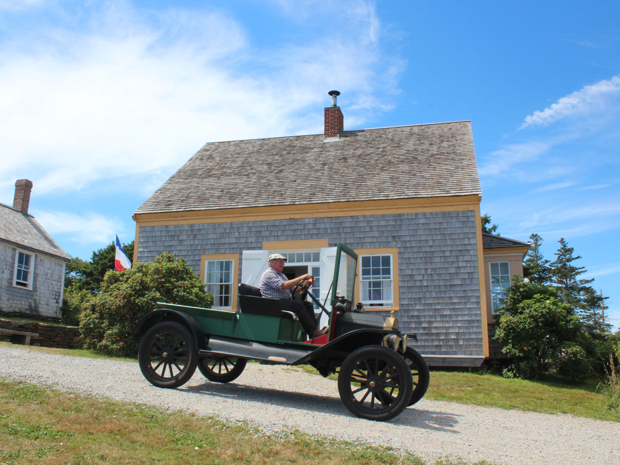 Antique car driving through the Historic Acadian Village of Nova Scotia