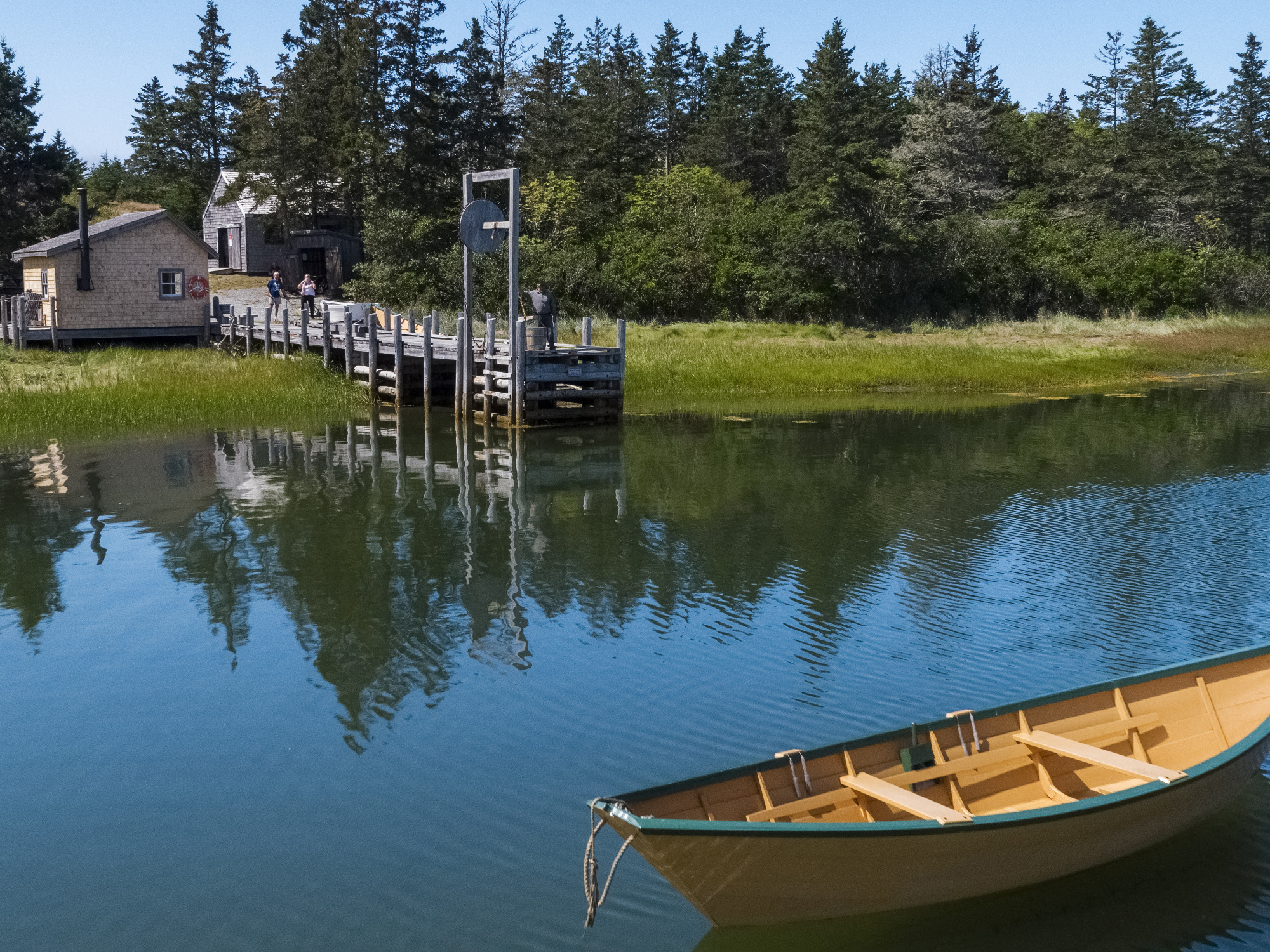 Dory floating in Pubnico Harbour with the wharf in the background.