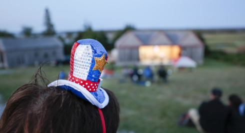 Acadian Day events in Pubnico. Spectator wearing a tiny Acadian themed top hat 